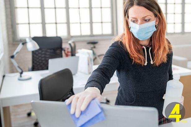 0_Woman-in-the-office-using-disinfectant-for-sanitizing-monitor-surface-during-COVID-19-pandemic
