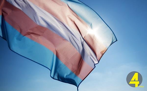 transgender pride flag waving on the blue sky